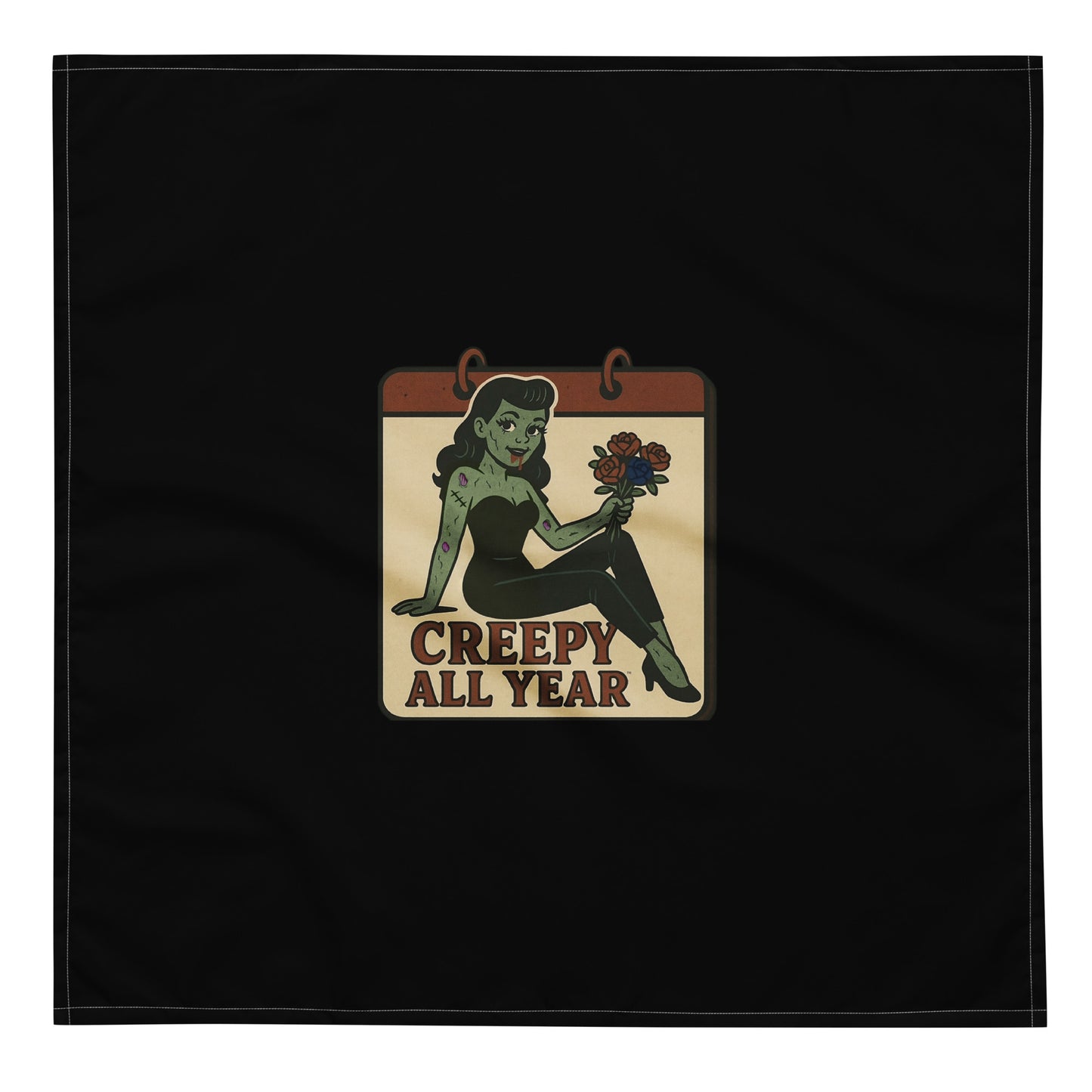 Black bandana with a vintage-style patch on the design area. The design features a green pinup-style zombie girl holding flowers, with a banner underneath that reads “CREEPY ALL YEAR.”