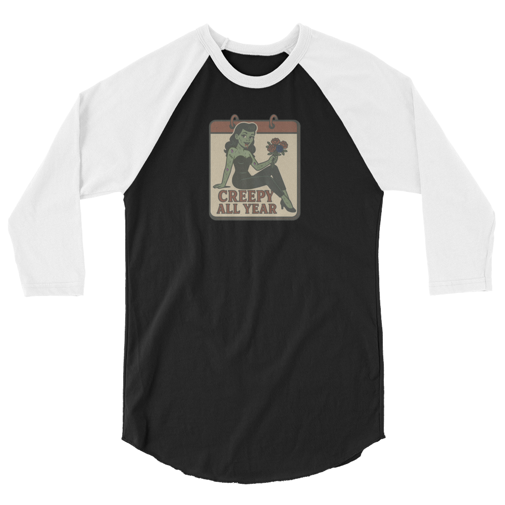 A black and white raglan t-shirt. The design features a green pinup-style zombie girl holding flowers, with a banner underneath that reads “CREEPY ALL YEAR.”