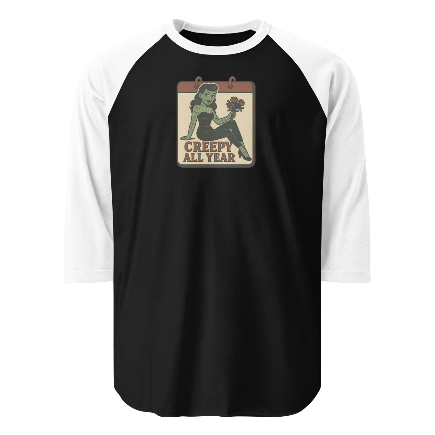 A black and white raglan t-shirt with a small vintage-style design. The design features a green pinup-style zombie girl holding flowers, with a banner underneath that reads “CREEPY ALL YEAR.”
