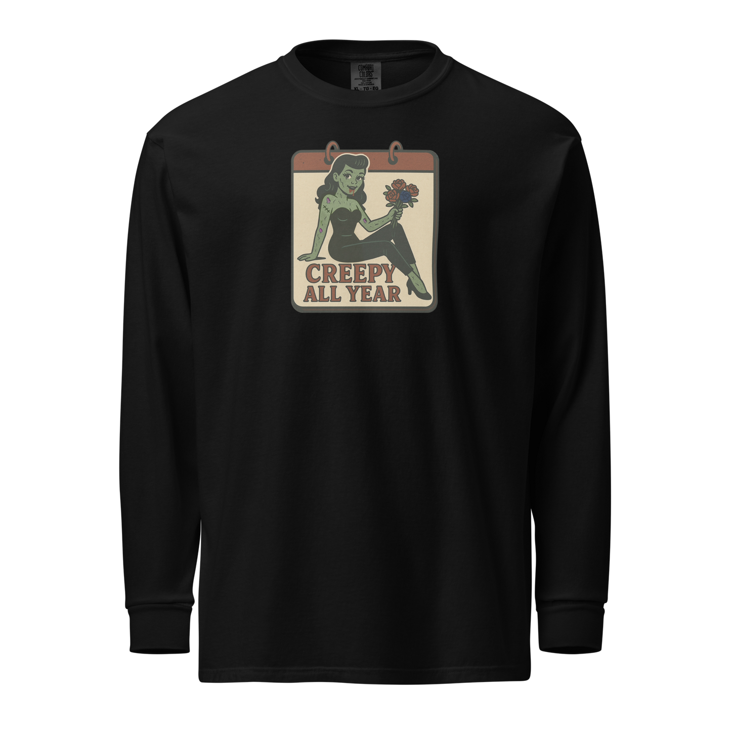 A black long sleeve shirt with vintage style design. The design on the front features a green pinup-style zombie girl holding flowers, with a banner underneath that reads “CREEPY ALL YEAR.”