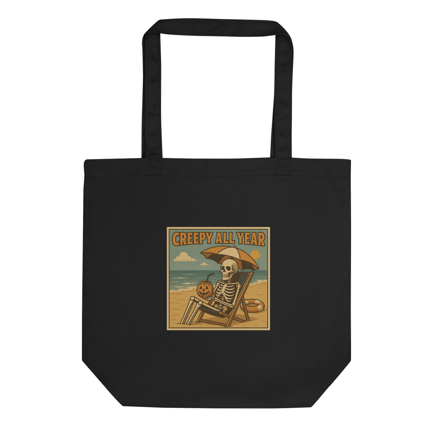 This is a eco tote bag with a retro-style illustration of a grinning skeleton lounging on a beach chair under an orange umbrella. The skeleton is holding a pumpkin-shaped drink cup with a straw and relaxing by the ocean, with a bright sun in the sky and a life preserver in the sand. The words “Creepy All Year” appear boldly at the top