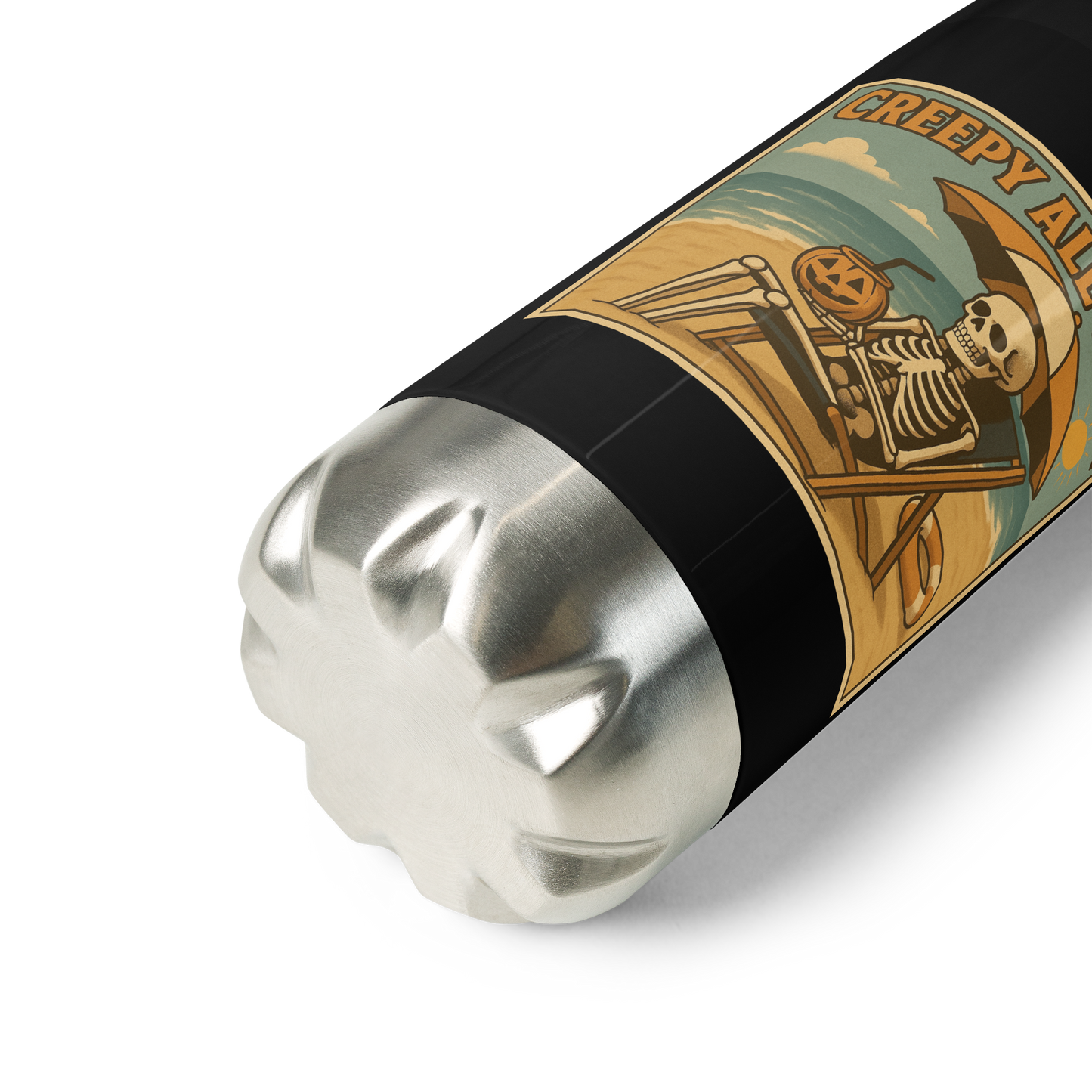 This is a zoom in of a black stainless steel water bottle with a retro-style illustration of a grinning skeleton lounging on a beach chair under an orange umbrella. The skeleton is holding a pumpkin-shaped drink cup with a straw and relaxing by the ocean, with a bright sun in the sky and a life preserver in the sand. The words “Creepy All Year” appear boldly at the top on the front side