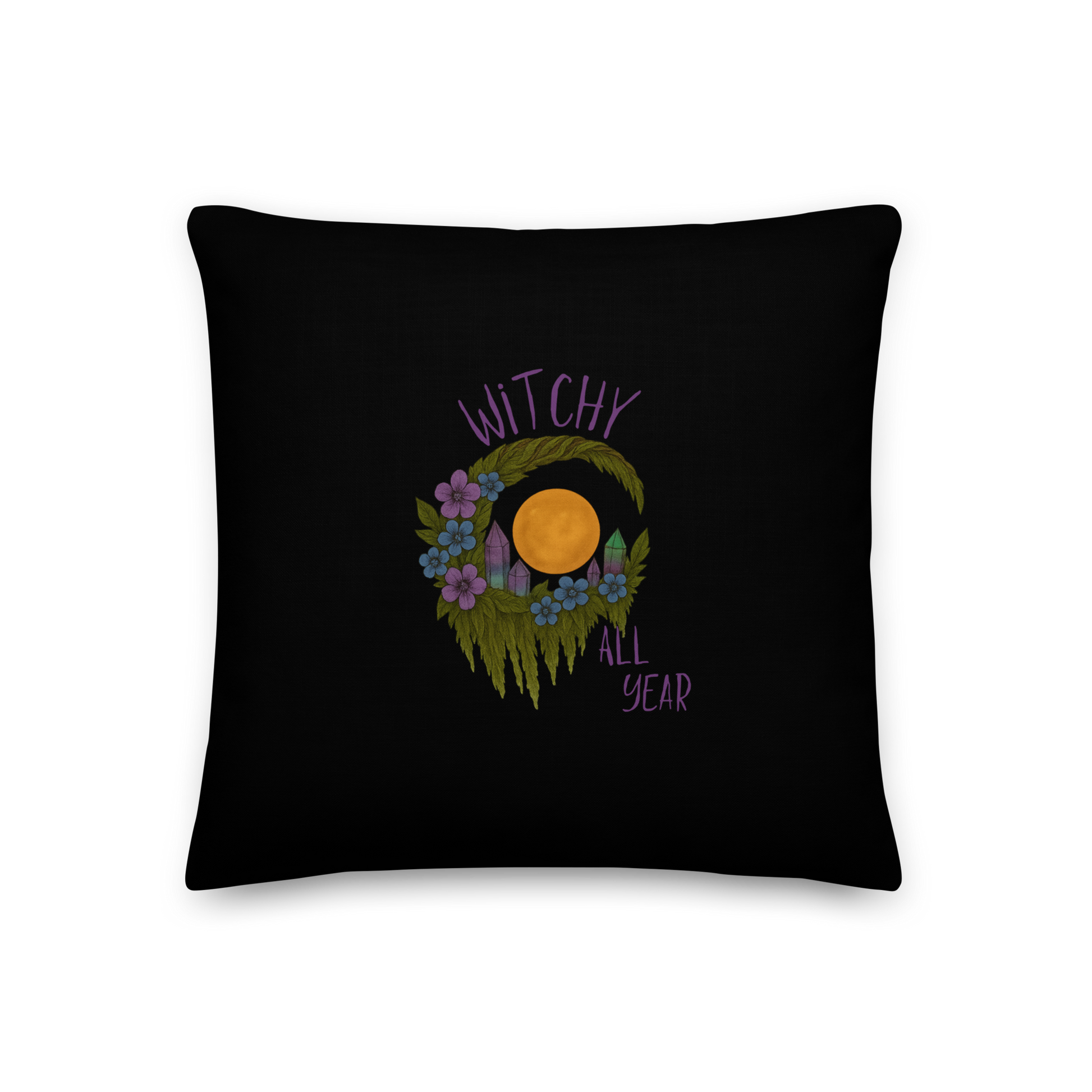 This is black throw pillow with a design of a hand-drawn wreath made of moss-covered branches wraps around a glowing sun. The wreath is decorated with purple and blue flowers, small amethyst and fluorite crystals, and strands of hanging moss. The words “Witchy” curve above the wreath and “All Year” sits on the bottom right 