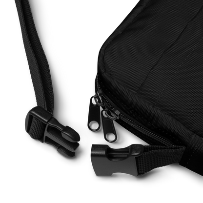 This is a black crossbody bag clasp with a Día de los Muertos–style illustration of a male and female skeleton holding hands, surrounded by marigolds, vines, and folk art patterns. The skeletons wear traditional black clothing, the man in a suit and hat, the woman with a floral crown with a red heart and leaves at the bottom and the text Creepy All Year. Rendered in warm tones of orange, green, and cream, symbolizing eternal love and remembrance on the front