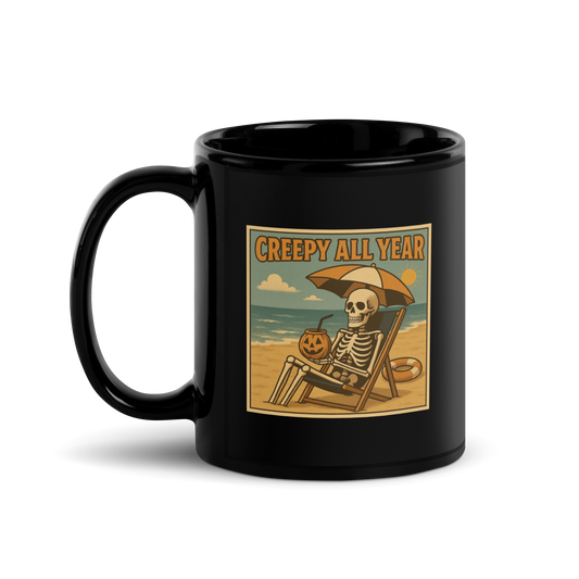 This is a black glossy mug with a retro-style illustration of a grinning skeleton lounging on a beach chair under an orange umbrella. The skeleton is holding a pumpkin-shaped drink cup with a straw and relaxing by the ocean, with a bright sun in the sky and a life preserver in the sand. The words “Creepy All Year” appear boldly at the top on the front side