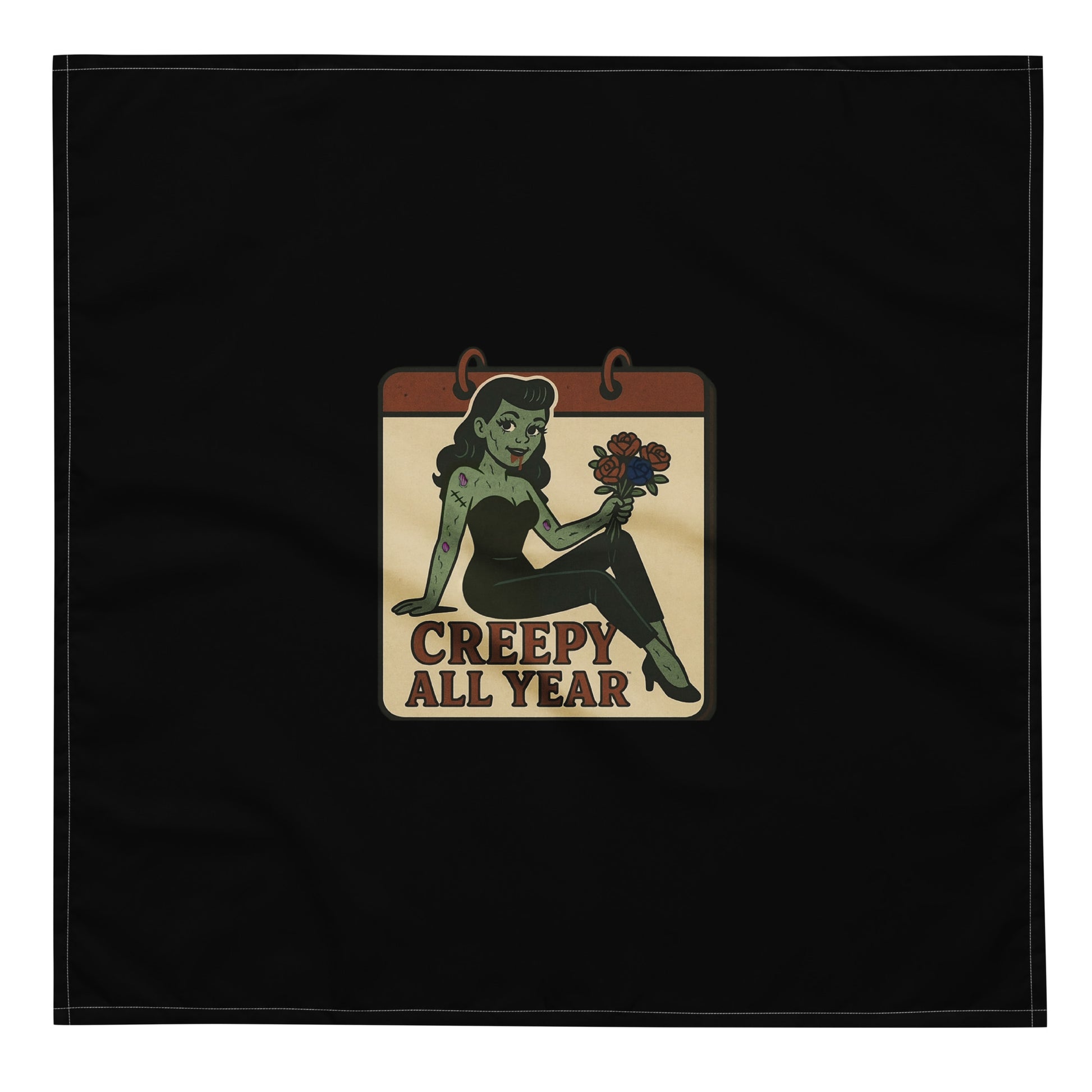 Black bandana with a vintage-style patch on the design area. The design features a green pinup-style zombie girl holding flowers, with a banner underneath that reads “CREEPY ALL YEAR.”