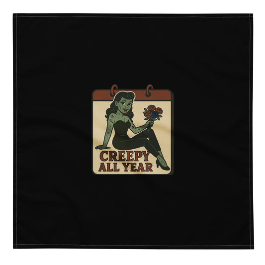 Black bandana with a vintage-style patch on the design area. The design features a green pinup-style zombie girl holding flowers, with a banner underneath that reads “CREEPY ALL YEAR.”
