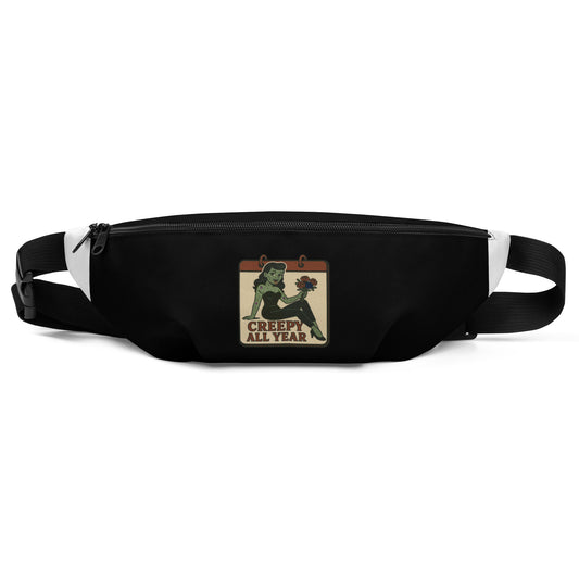 Black fanny pack with a graphic design. The design features a green pinup-style zombie girl holding flowers, with a banner underneath that reads “CREEPY ALL YEAR.”