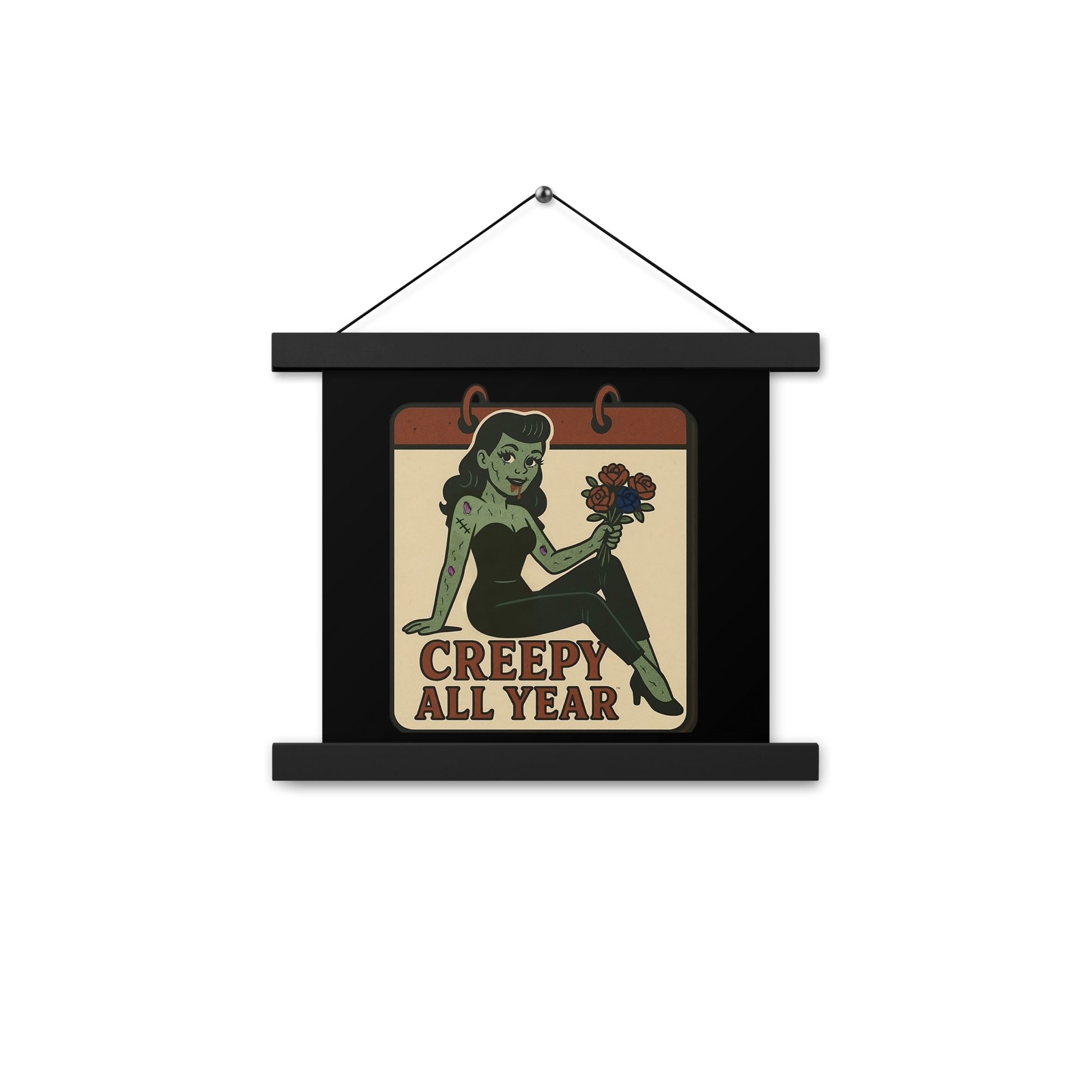 Black hanging wall art with two wood pieces on the top and bottom and a black hanger with a vintage-style patch on the design. The design features a green pinup-style zombie girl holding flowers, with a banner underneath that reads “CREEPY ALL YEAR.”