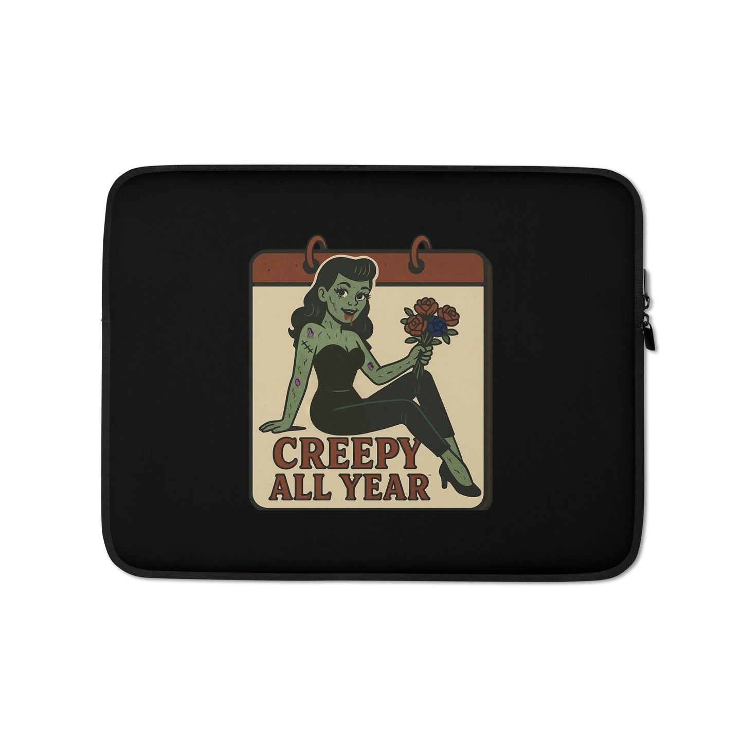 Laptop sleeve with a graphic design. The design features a green pinup-style zombie girl holding flowers, with a banner underneath that reads “CREEPY ALL YEAR.”