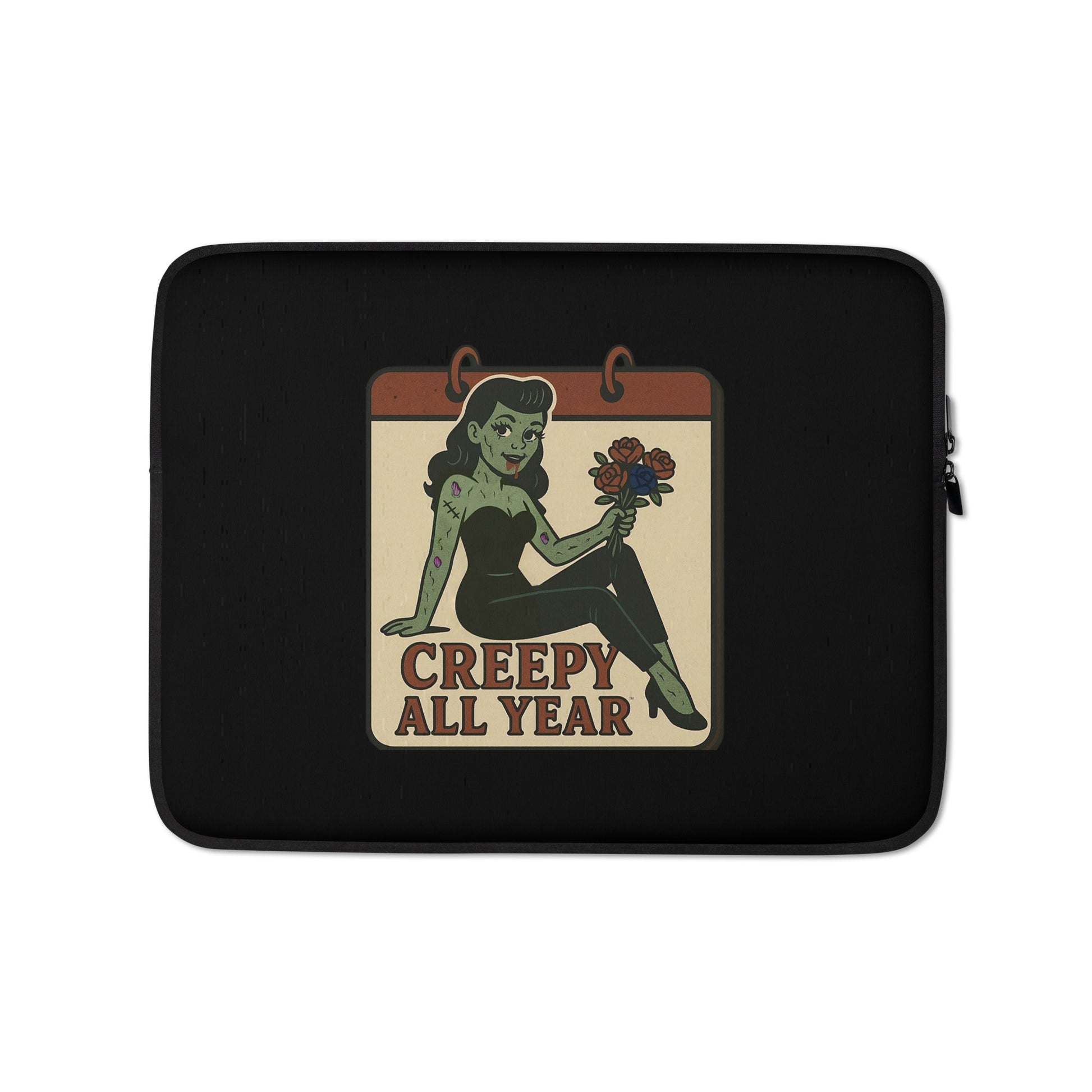 Laptop sleeve with a graphic design. The design features a green pinup-style zombie girl holding flowers, with a banner underneath that reads “CREEPY ALL YEAR.”