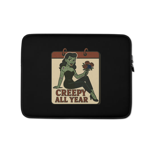 Laptop sleeve with a graphic design. The design features a green pinup-style zombie girl holding flowers, with a banner underneath that reads “CREEPY ALL YEAR.”