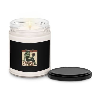 White candle in a jar with a black label featuring a zombie graphic and text that reads Creepy All Year