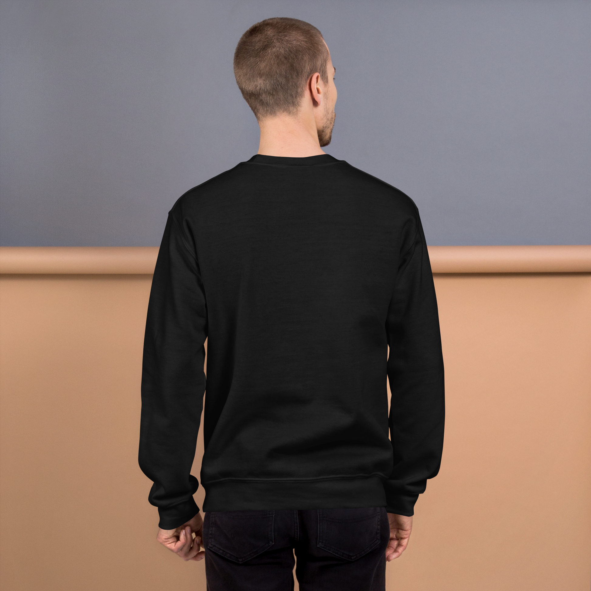 Man wearing a black sweatshirt against a gray and brown background