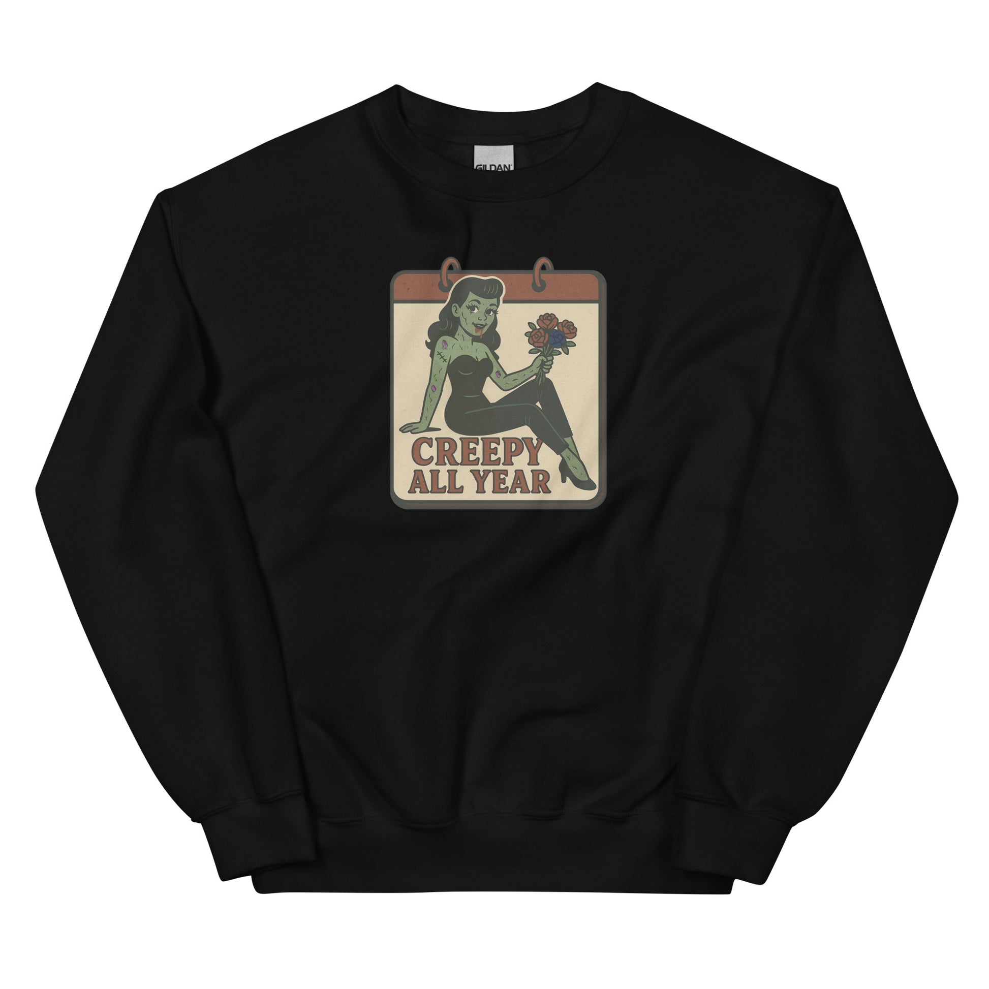 A black sweatshirt with a vintage-style design on the front. The design features a green pinup-style zombie girl holding flowers, with a banner underneath that reads “CREEPY ALL YEAR.”