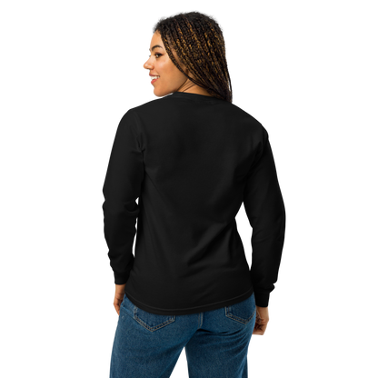 A girl with braids wearing jeans and showing the back of a black long sleeve t-shirt. The design on the front features a green pinup-style zombie girl holding flowers, with a banner underneath that reads “CREEPY ALL YEAR.”