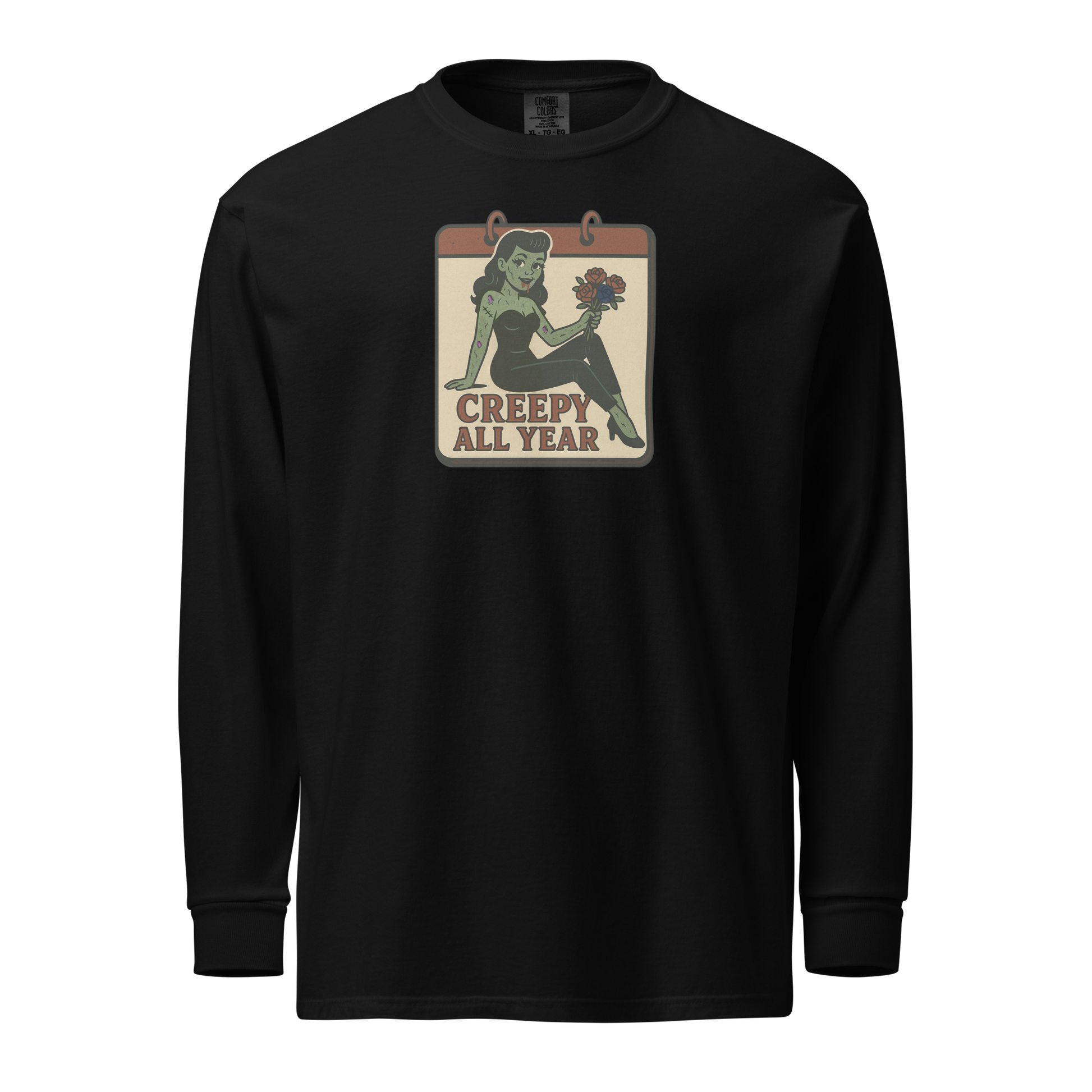 A black long sleeve shirt with vintage style design. The design on the front features a green pinup-style zombie girl holding flowers, with a banner underneath that reads “CREEPY ALL YEAR.”