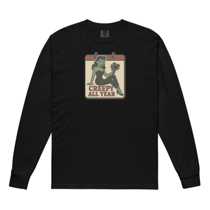 A black long sleeve t-shirt. The design features a green pinup-style zombie girl holding flowers, with a banner underneath that reads “CREEPY ALL YEAR.”