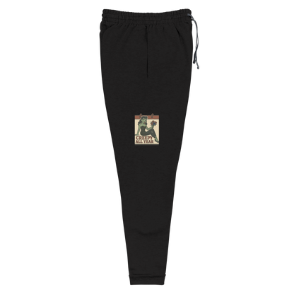 Black joggers with a vintage-style design on the front. The design features a green pinup-style zombie girl holding flowers, with a banner underneath that reads “CREEPY ALL YEAR.”