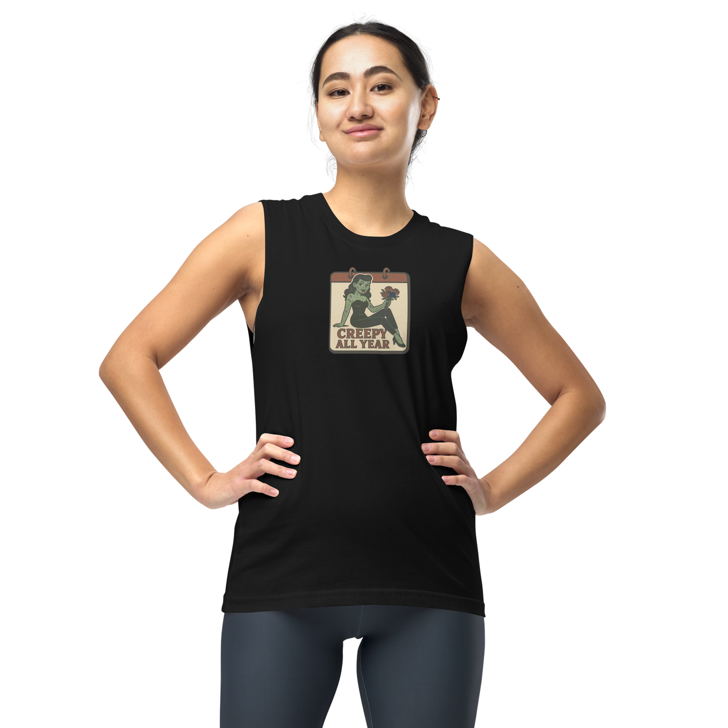 A girl with dark hair pulled back wearing leggings and muscle shirt with vintage style design. The design on the front features a green pinup-style zombie girl holding flowers, with a banner underneath that reads “CREEPY ALL YEAR.”