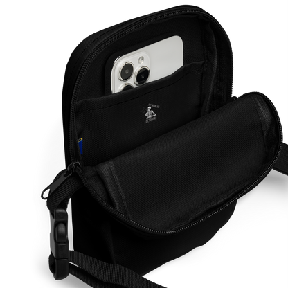 This is the inside of a black crossbody bag that has a bored skeleton with his head resting in his hand and he has spider webs and bats around him and the text reads just waiting for October
