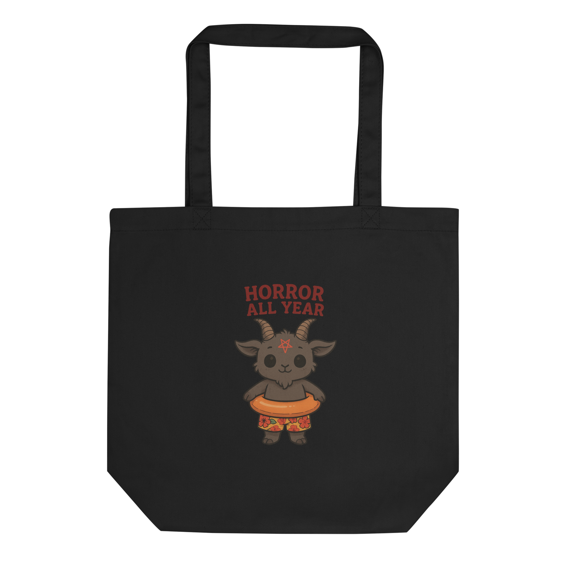 This is a black tote bag that has a cartoon illustration of a baby Baphomet goat with curved horns and a playful grin, wearing bright floral swim trunks while floating in a colorful inner tube. The character is set against a light background with the bold text “Horror All Year” above in red letters 