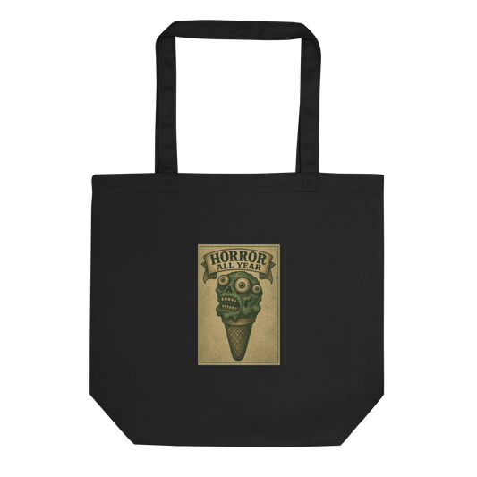 This is a black tote bag that is a vintage-style illustration of a zombie-themed ice cream cone with a green, melting undead face and bulging eyeballs. Above the cone, a horror banner reads "Horror All Year" on a distressed parchment background