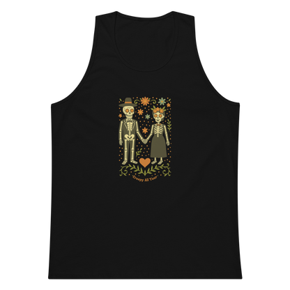This is a black men's tank top with a Día de los Muertos–style illustration of a male and female skeleton holding hands, surrounded by marigolds, vines, and folk art patterns. The skeletons wear traditional black clothing, the man in a suit and hat, the woman with a floral crown with a red heart and leaves at the bottom and the text Creepy All Year. Rendered in warm tones of orange, green, and cream, symbolizing eternal love and remembrance