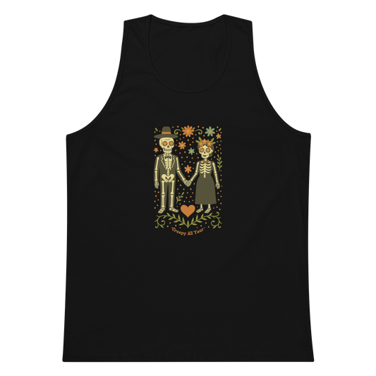 This is a black men's tank top with a Día de los Muertos–style illustration of a male and female skeleton holding hands, surrounded by marigolds, vines, and folk art patterns. The skeletons wear traditional black clothing, the man in a suit and hat, the woman with a floral crown with a red heart and leaves at the bottom and the text Creepy All Year. Rendered in warm tones of orange, green, and cream, symbolizing eternal love and remembrance