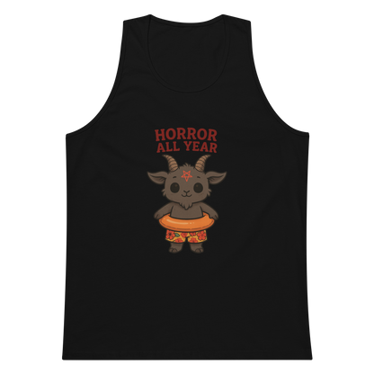 This is a black tank top with a cartoon illustration of a baby Baphomet goat with curved horns and a playful grin, wearing bright floral swim trunks while floating in a colorful inner tube. The character is set against a light background with the bold text “Horror All Year” above in red letters