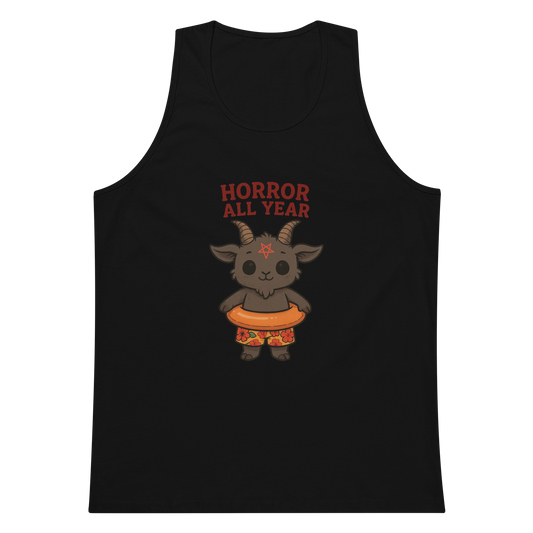 This is a black tank top with a cartoon illustration of a baby Baphomet goat with curved horns and a playful grin, wearing bright floral swim trunks while floating in a colorful inner tube. The character is set against a light background with the bold text “Horror All Year” above in red letters
