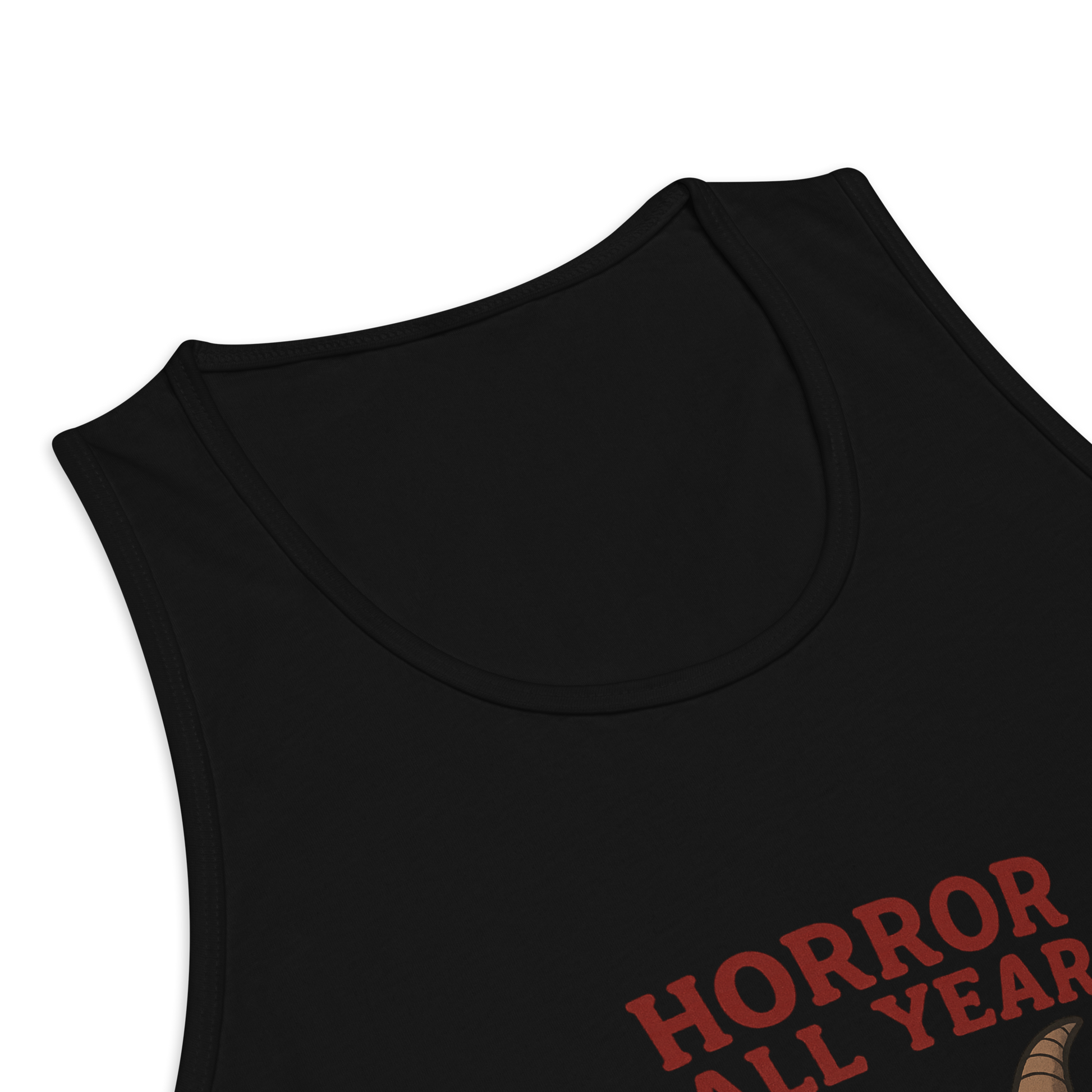 This is a zoom in of a black tank top with a cartoon illustration of a baby Baphomet goat with curved horns and a playful grin, wearing bright floral swim trunks while floating in a colorful inner tube. The character is set against a light background with the bold text “Horror All Year” above in red letters