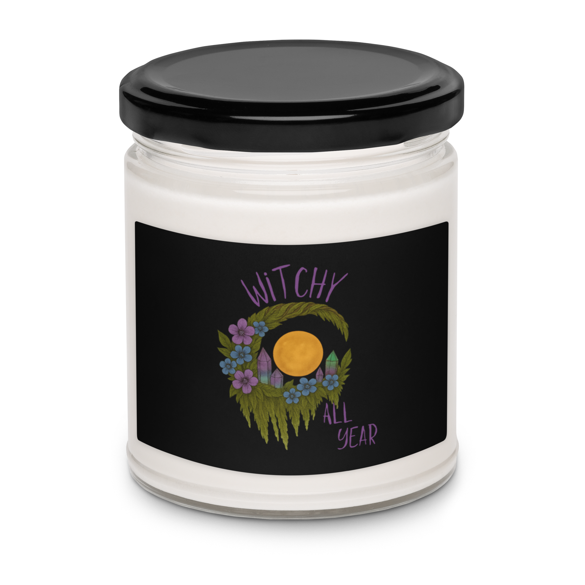 This is a white candle with a design of a hand-drawn wreath made of moss-covered branches wraps around a glowing sun. The wreath is decorated with purple and blue flowers, small amethyst and fluorite crystals, and strands of hanging moss. The words “Witchy” curve above the wreath and “All Year” sits on the bottom right 