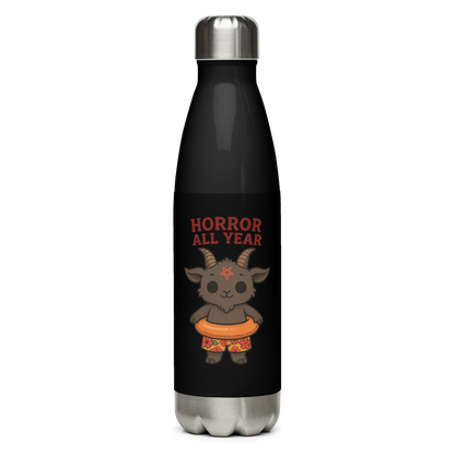 This is a black stainless steel water bottle with a cartoon illustration of a baby Baphomet goat with curved horns and a playful grin, wearing bright floral swim trunks while floating in a colorful inner tube. The character is set against a light background with the bold text “Horror All Year” above in red letters 