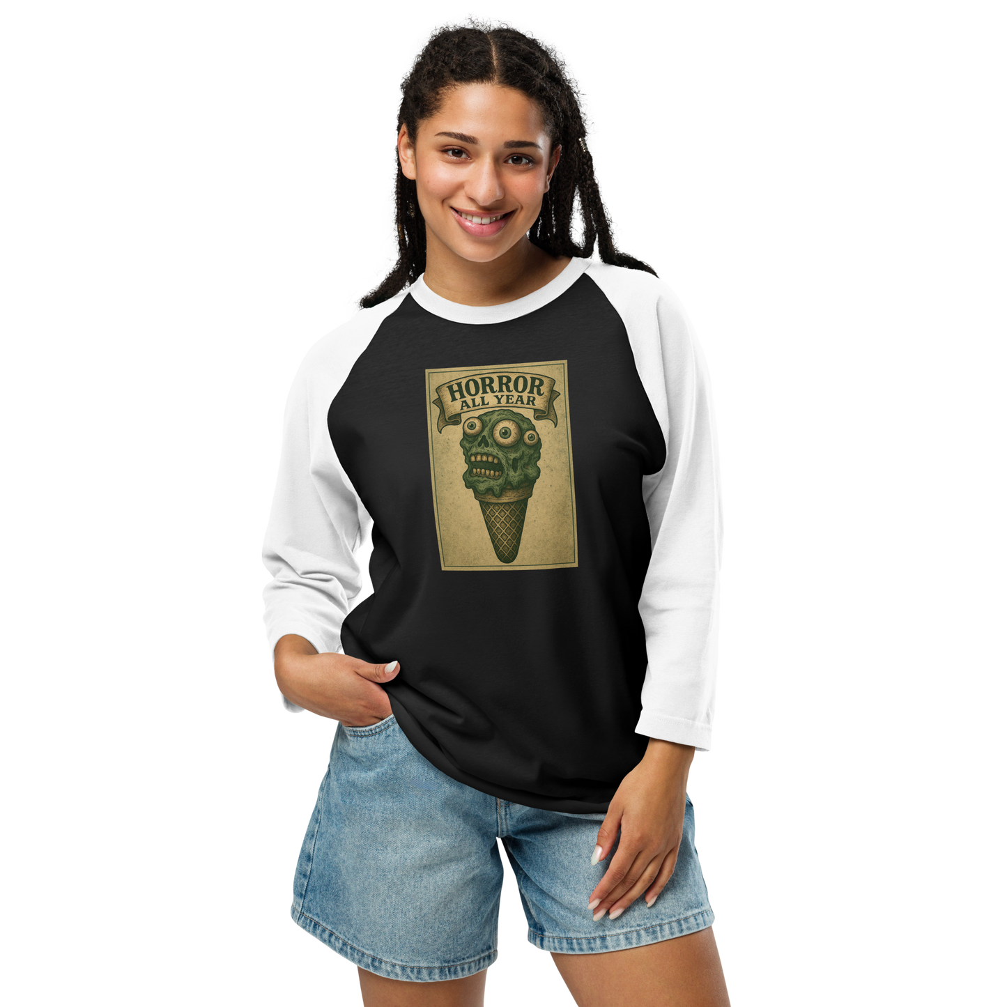 This is a woman with black hair wearing a black and white raglan shirt that is a vintage-style illustration of a zombie-themed ice cream cone with a green, melting undead face and bulging eyeballs. Above the cone, a horror banner reads "Horror All Year" on a distressed parchment background