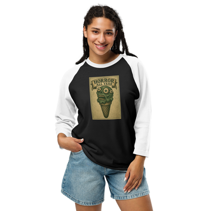 This is a woman with black hair wearing a black and white raglan shirt that is a vintage-style illustration of a zombie-themed ice cream cone with a green, melting undead face and bulging eyeballs. Above the cone, a horror banner reads "Horror All Year" on a distressed parchment background