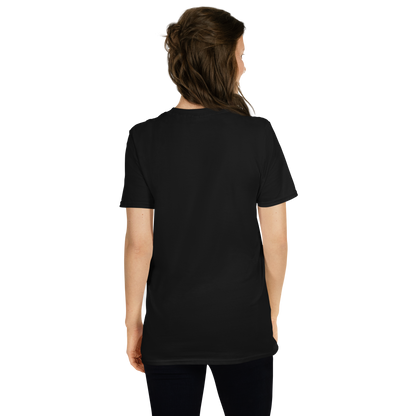 This is a woman with dark hair showing the back of a black t-shirt with a Día de los Muertos–style illustration of a male and female skeleton holding hands, surrounded by marigolds, vines, and folk art patterns. The skeletons wear traditional black clothing, the man in a suit and hat, the woman with a floral crown with a red heart and leaves at the bottom and the text Creepy All Year. Rendered in warm tones of orange, green, and cream, symbolizing eternal love and remembrance on the front side