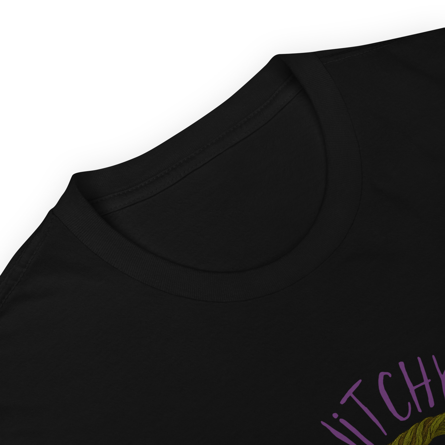 This is a zoom in of a black t-shirt with a design of a hand-drawn wreath made of moss-covered branches wraps around a glowing sun. The wreath is decorated with purple and blue flowers, small amethyst and fluorite crystals, and strands of hanging moss. The words “Witchy” curve above the wreath and “All Year” sits on the bottom right 
