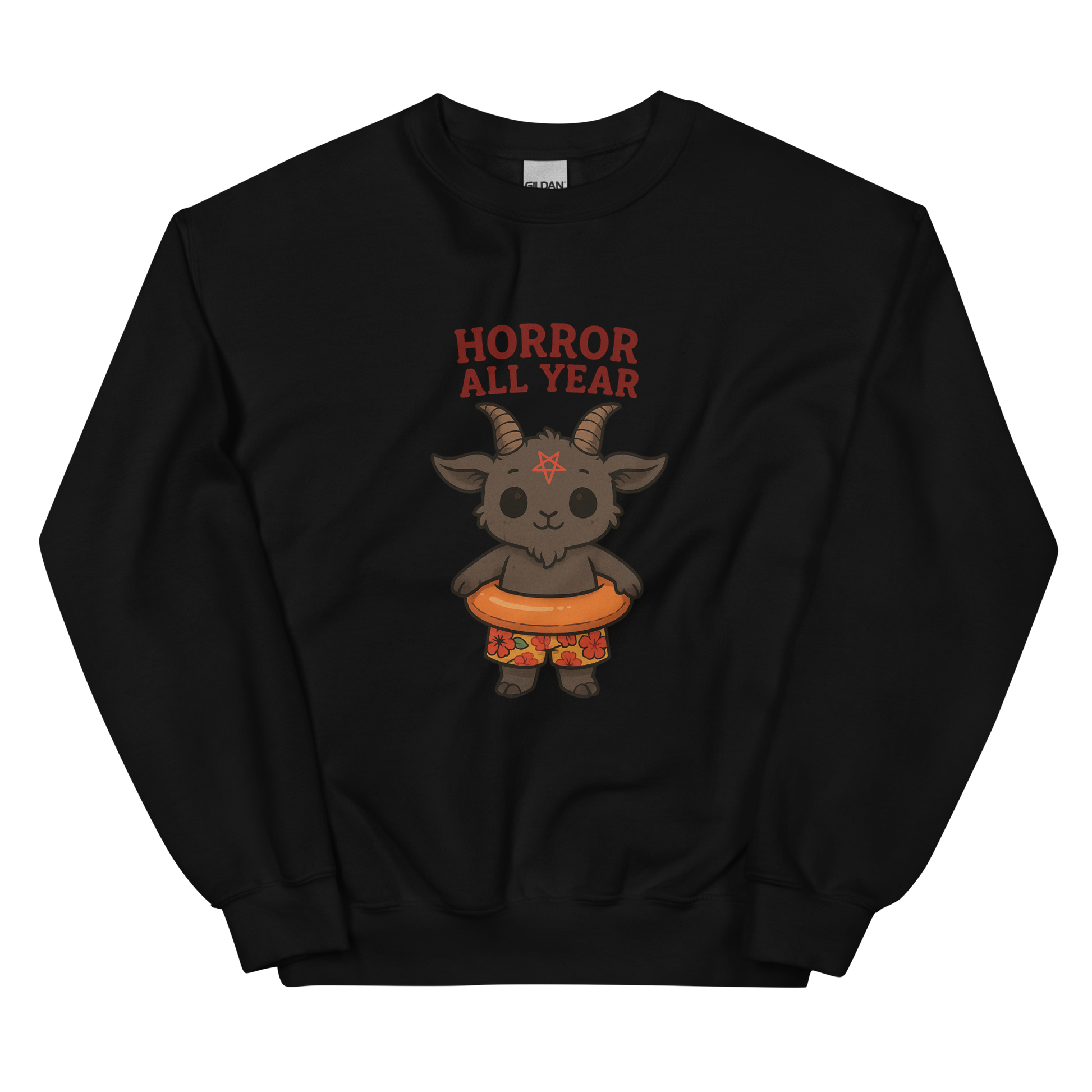 This is a black sweatshirt with a cartoon illustration of a baby Baphomet goat with curved horns and a playful grin, wearing bright floral swim trunks while floating in a colorful inner tube. The character is set against a light background with the bold text “Horror All Year” above in red letters
