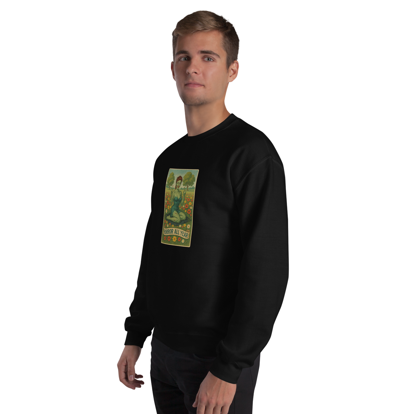 This is a man with blonde hair wearing a black sweatshirt with a design illustration of a sassy zombie pinup girl standing in a floral field, wearing tattered lingerie and flipping off the viewer with both hands. She has green skin, vintage curls, and a bold attitude. The design blends horror and humor, with a pastel color palette and creepy cute vibes