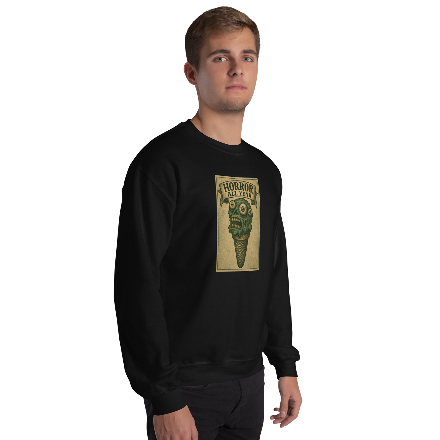 This is a man with brown hair wearing a black sweatshirt that is a vintage-style illustration of a zombie-themed ice cream cone with a green, melting undead face and bulging eyeballs. Above the cone, a horror banner reads "Horror All Year" on a distressed parchment background