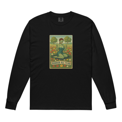 This is a black long sleeve shirt with a design illustration of a sassy zombie pinup girl standing in a floral field, wearing tattered lingerie and flipping off the viewer with both hands. She has green skin, vintage curls, and a bold attitude. The design blends horror and humor, with a pastel color palette and creepy cute vibes