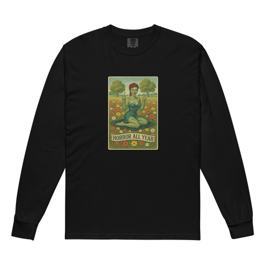 This is a black long sleeve shirt with a design illustration of a sassy zombie pinup girl standing in a floral field, wearing tattered lingerie and flipping off the viewer with both hands. She has green skin, vintage curls, and a bold attitude. The design blends horror and humor, with a pastel color palette and creepy cute vibes