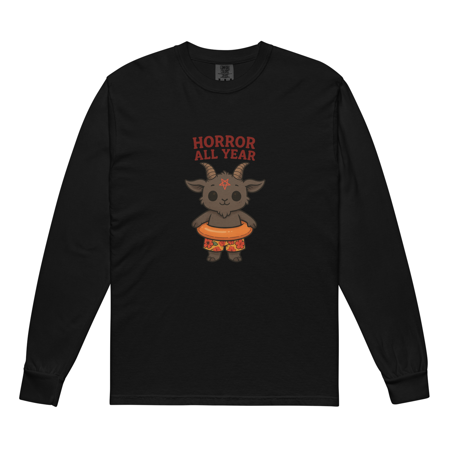 This is a black long sleeve shirt with a cartoon illustration of a baby Baphomet goat with curved horns and a playful grin, wearing bright floral swim trunks while floating in a colorful inner tube. The character is set against a light background with the bold text “Horror All Year” above in red letters
