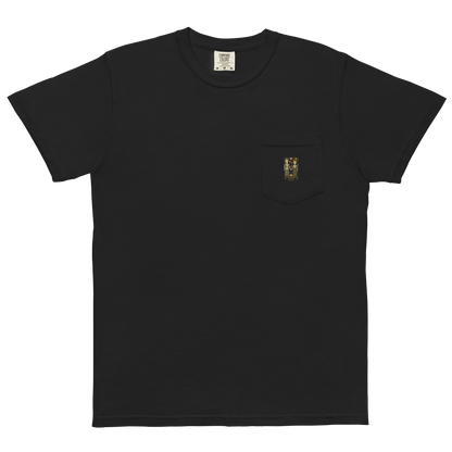 This is a black pocket t-shirt with a Día de los Muertos–style illustration of a male and female skeleton holding hands, surrounded by marigolds, vines, and folk art patterns. The skeletons wear traditional black clothing, the man in a suit and hat, the woman with a floral crown with a red heart and leaves at the bottom and the text Creepy All Year. Rendered in warm tones of orange, green, and cream, symbolizing eternal love and remembrance