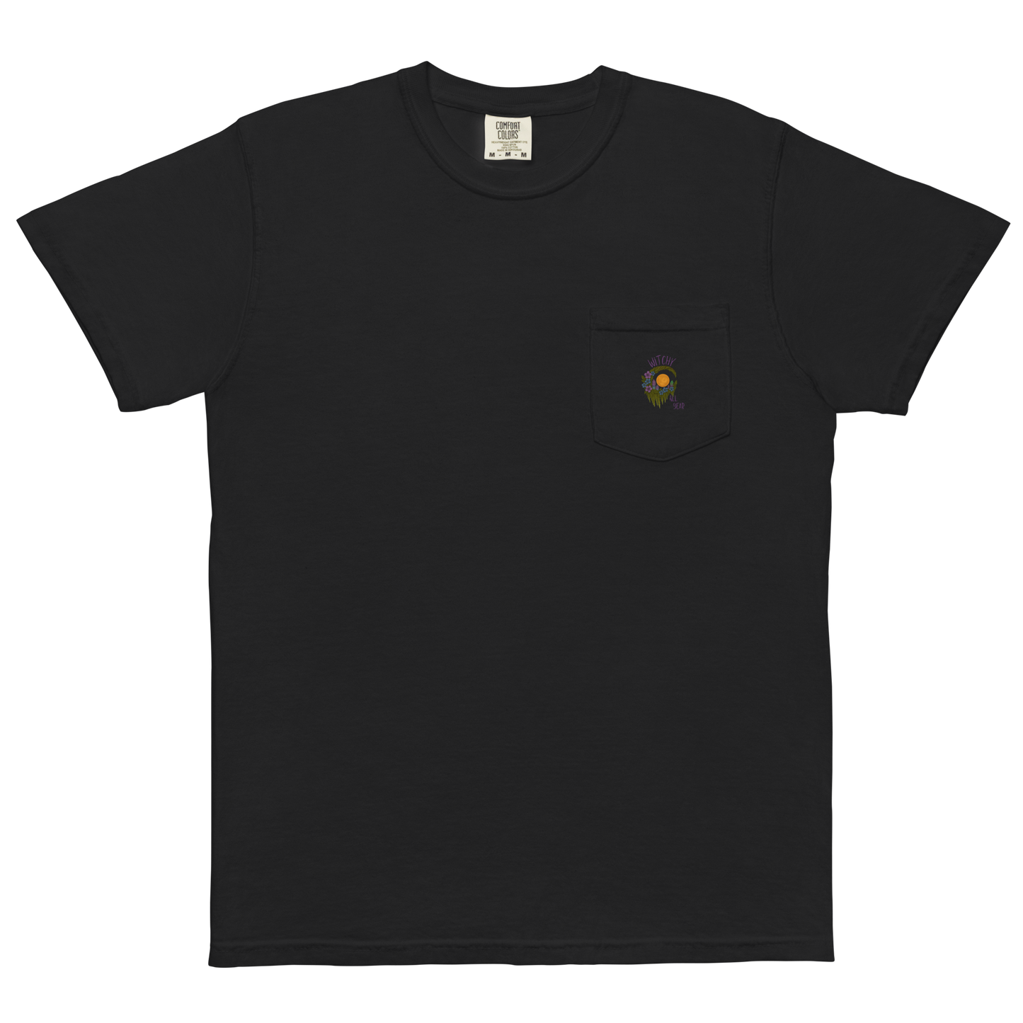 This is a black pocket t-shirt with a design of a hand-drawn wreath made of moss-covered branches wraps around a glowing sun. The wreath is decorated with purple and blue flowers, small amethyst and fluorite crystals, and strands of hanging moss. The words “Witchy” curve above the wreath and “All Year” sits on the bottom right 