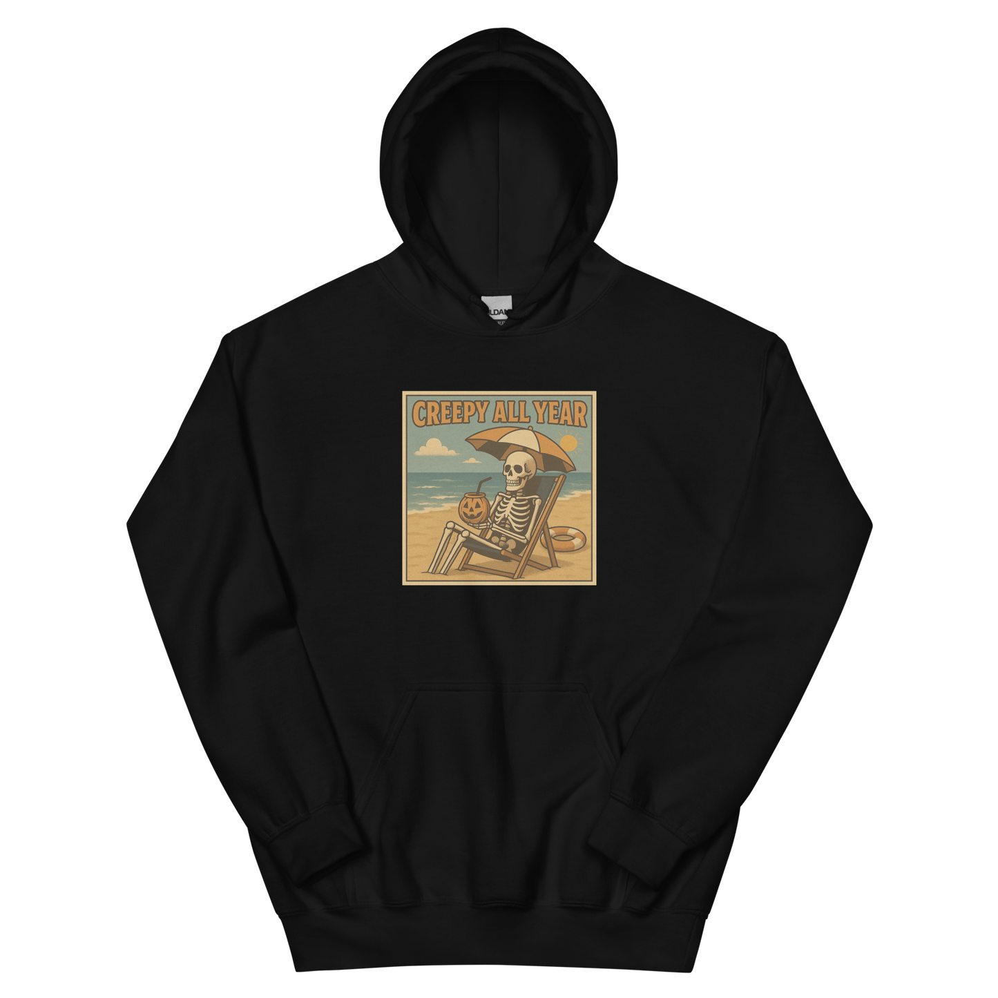 This is a black hoodie with a retro-style illustration of a grinning skeleton lounging on a beach chair under an orange umbrella. The skeleton is holding a pumpkin-shaped drink cup with a straw and relaxing by the ocean, with a bright sun in the sky and a life preserver in the sand. The words “Creepy All Year” appear boldly at the top