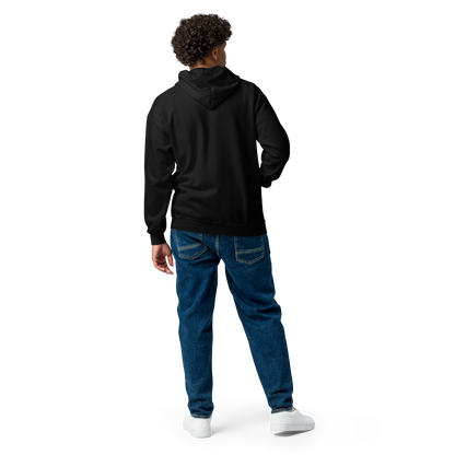 This is man showing the back of a black zip up hoodie with a Día de los Muertos–style illustration of a male and female skeleton holding hands, surrounded by marigolds, vines, and folk art patterns. The skeletons wear traditional black clothing, the man in a suit and hat, the woman with a floral crown with a red heart and leaves at the bottom and the text Creepy All Year. Rendered in warm tones of orange, green, and cream, symbolizing eternal love and remembrance on the front side