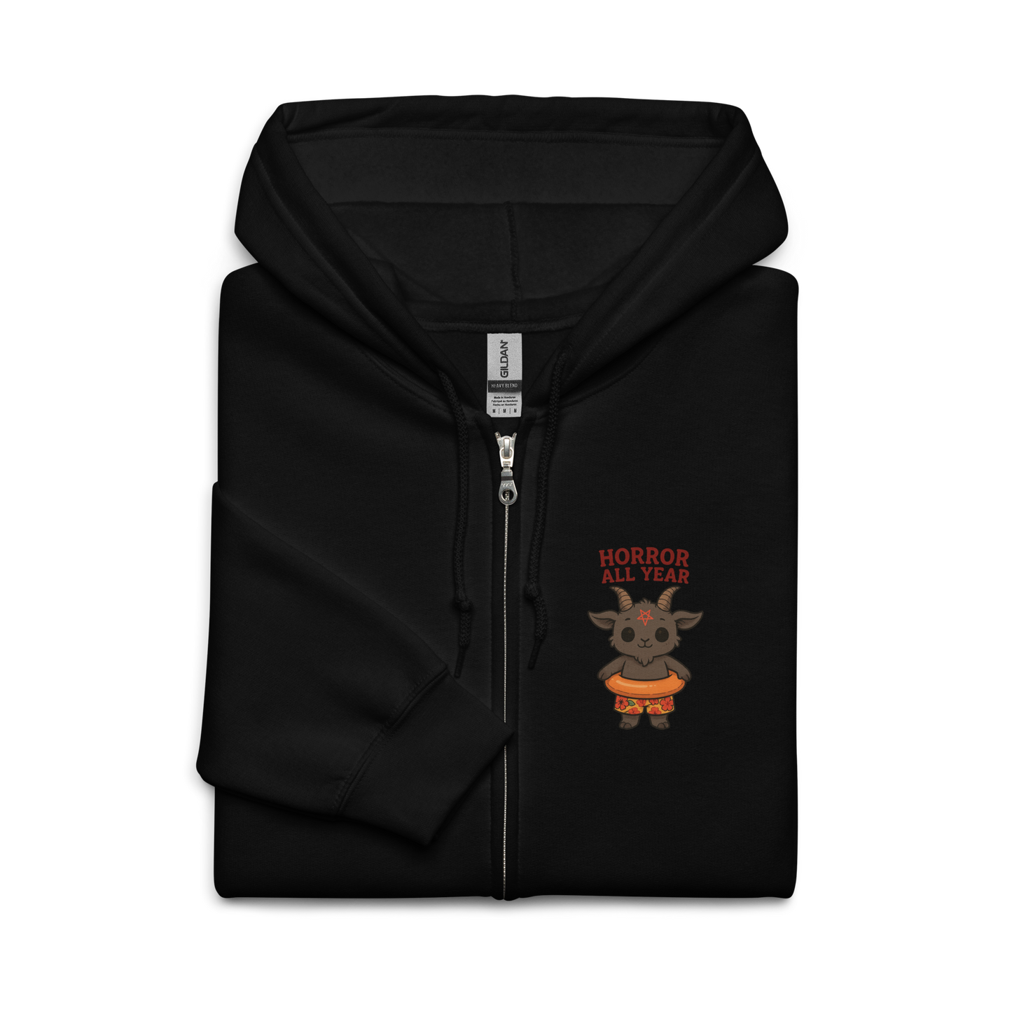 This is a folded black zip-up hoodie with a cartoon illustration of a baby Baphomet goat with curved horns and a playful grin, wearing bright floral swim trunks while floating in a colorful inner tube. The character is set against a light background with the bold text “Horror All Year” above in red letters