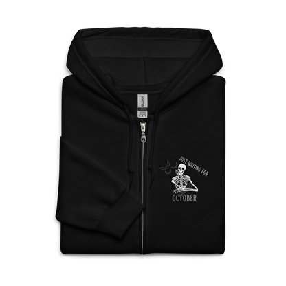 This is a folded black zip-up hoodie that has a bored skeleton with his head resting in his hand and he has spider webs and bats around him and the text reads just waiting for October
